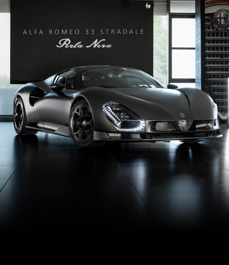 Alfa Romeo 33 Stradale Perla Nera en color negro, visto de frente en un  showroom, con carrocería deportiva de fibra de carbono, faros LED distintivos y  detalles aerodinámicos.
